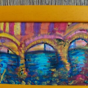 K&ouml;nnte beinhalten: Abstrakte Malerei einer Br&uuml;cke mit bogenf&ouml;rmigen &Ouml;ffnungen, in einem gelben Rahmen. Das Kunstwerk zeigt eine farbenfrohe Darstellung der Br&uuml;cke und des Wassers, mit Blau-, Rosa- und Gelbt&ouml;nen.