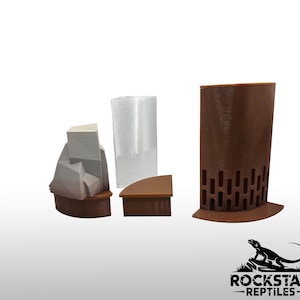 May include: A set of three 3D printed reptile enclosure accessories including a gray rock-shaped hide, a translucent white cylindrical tower, and a brown curved wall piece with a repeating oval cutout pattern, all featuring brown bases.