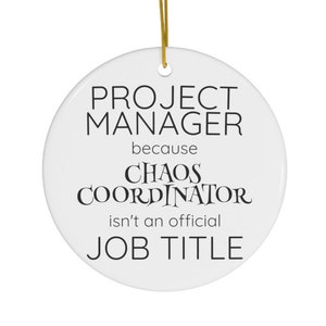May include: White ceramic ornament with black text that reads "Project Manager because Chaos Coordinator isn't an official job title".