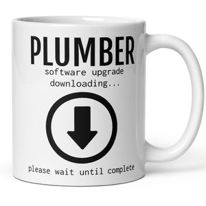 May include: White ceramic mug with the word "PLUMBER" in bold black letters. Below, the text reads "software upgrade downloading..." and "please wait until complete". A black arrow in a circle is also featured.