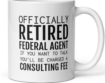 May include: White ceramic coffee mug with black text that reads "Officially Retired Federal Agent If you want to talk you'll be charged a Consulting Fee."
