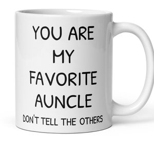 May include: White ceramic coffee mug with black text that reads "You are my favourite auncle Don't tell the others."