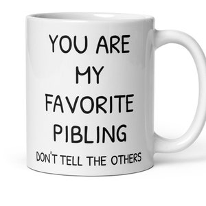 May include: White ceramic mug with black text that reads "You are my favourite pibling don't tell the others".