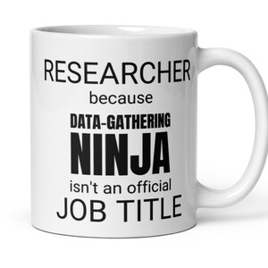 May include: White ceramic mug with black text that reads "Researcher because Data-Gathering Ninja isn't an official Job Title".