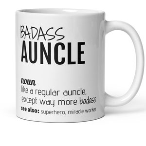 May include: White ceramic coffee mug with black text that reads "BADASS AUNCLE" and a definition of the word "auncle" as "like a regular auncle, except way more badass." The text also says "see also: superhero, miracle worker."