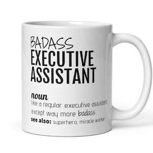 May include: White ceramic coffee mug with black text that reads "BADASS EXECUTIVE ASSISTANT noun like a regular executive assistant, except way more badass see also: superhero, miracle worker"