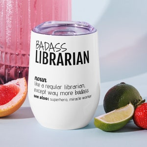May include: White stainless steel wine tumbler with a black inscription that reads "BADASS LIBRARIAN noun like a regular librarian, except way more badass see also: superhero, miracle worker".