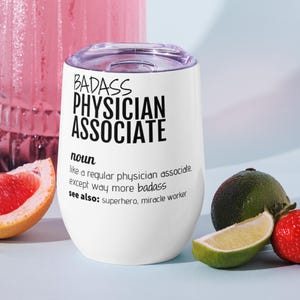 May include: White stainless steel wine tumbler with a black graphic that reads "BADASS PHYSICIAN ASSOCIATE noun like a regular physician associate, except way more badass see also: superhero, miracle worker"