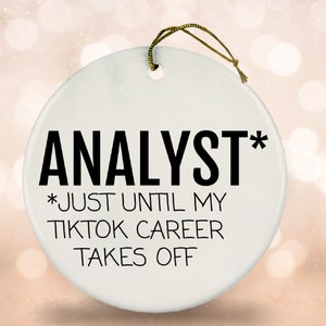 May include: White ceramic bauble with black text that reads "Analyst* *Just until my TikTok career takes off".