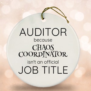 May include: White ceramic ornament with black text that reads "AUDITOR because CHAOS COORDINATOR isn't an official JOB TITLE".