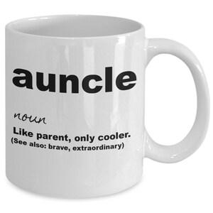 May include: White ceramic coffee mug with black text that reads "auncle noun Like parent, only cooler. (See also: brave, extraordinary)"