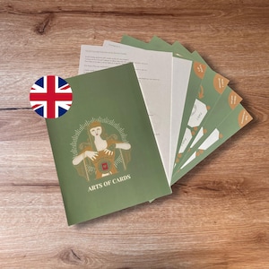 Könnte beinhalten: Ein Set aus Anleitungskarten und einem Heft mit dem Titel Arts of Cards mit grünem Einband, das eine stilisierte Illustration einer Person mit einem Herzsymbol zeigt. Das Set enthält mehrere gestapelte Karten mit Beschriftungen wie Make a decision.