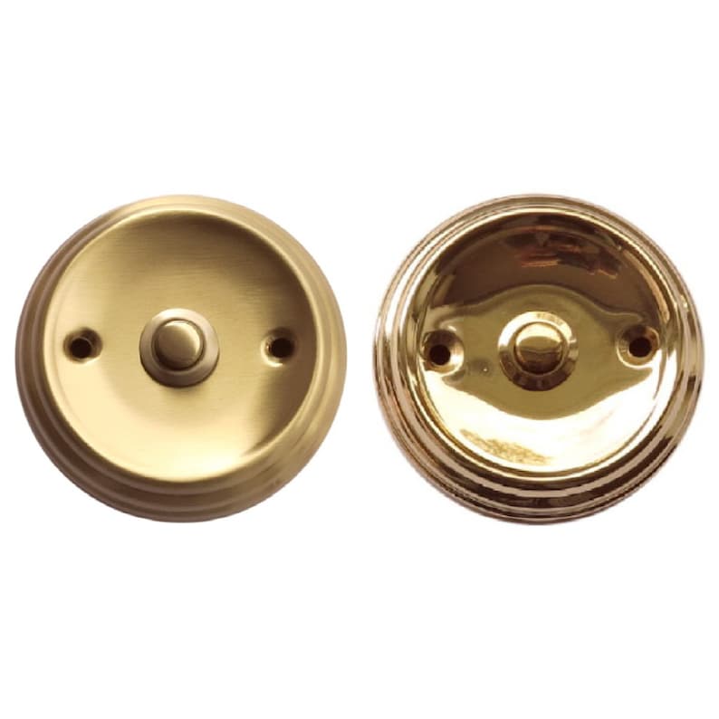 May include: Two round, polished brass doorbells with a single button in the center. The doorbells have a raised, decorative rim.