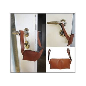 Könnte beinhalten: Ein brauner Leder-Türgriffschutz mit einer Schlaufe zum Öffnen der Tür. Die Abdeckung ist an einem Türgriff angebracht und auch flach gelegt.