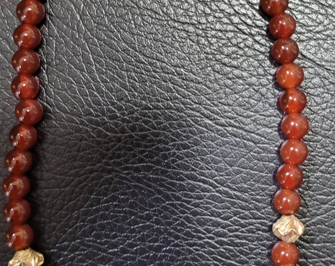 20 inch in length. Nine melon shaped carnelian beads, 46 round carnelian, 14K gold twisted Hogan beads, gold lobster clasp.
