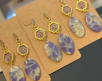 Pendientes translúcidos morados y dorados con dije de flor