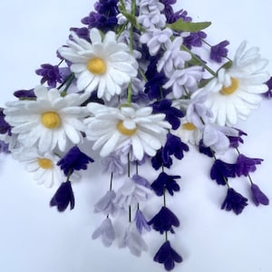 Op de afbeelding: Een boeket van viltbloemen met witte madeliefjes en paarse lavendel. De bloemen zijn in een tros gerangschikt en hebben een realistisch uiterlijk.