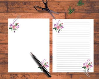 May include: Two sheets of white paper with a floral design in the corner. The paper on the left is blank, while the paper on the right has lined writing paper. A pen is lying on the blank sheet of paper.