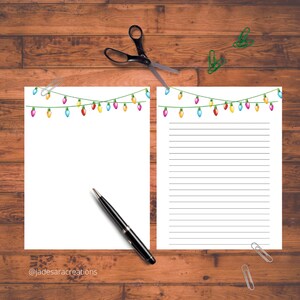May include: Two printable sheets of paper with a string of colorful Christmas lights at the top. The left sheet is blank and the right sheet has lined paper.