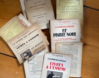 May include: A collection of vintage books with French titles, including "La Guerre des Cerveaux" and "Le Diable Noir". The books are in various states of wear and tear, with some showing signs of age and use.
