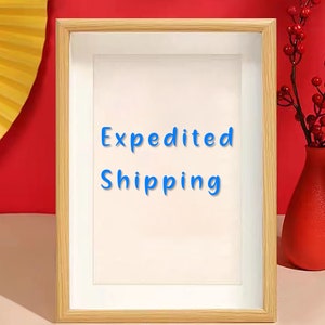 May include: A wooden picture frame with a white mat and a white background. The text "Expedited Shipping" is written in blue on the white background.