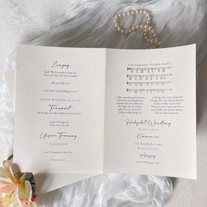 Pu&ograve; includere: Un programma di cerimonia di matrimonio con sfondo bianco e testo nero. Il programma include l'ordine degli eventi, come la processione, le letture, i voti e la recessione. Il programma include anche i nomi degli sposi, la data del matrimonio e il luogo della cerimonia.