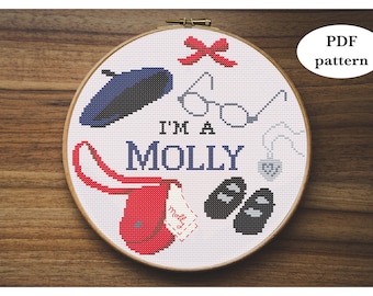 May include: A white embroidery hoop with a cross-stitch design featuring a red purse, blue beret, glasses, a necklace with a heart pendant, black slippers, and a red bow. The text "I'm a Molly" is stitched in blue thread.