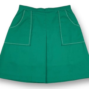 May include: A green skirt with white stitching around the pockets. The skirt has a simple, A-line silhouette.