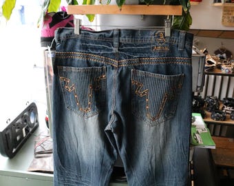 Calça jeans Attitude | Jeans vintage anos 2000 em lavagem escura com bolsos listrados e tachas | Calça estilo streetwear western