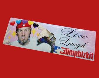 May include: A white sticker featuring a photograph of a man wearing a red baseball cap and a white shirt. The text "Live Laugh Limpbizkit" is printed in black on the sticker.