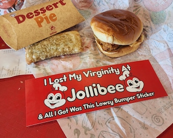 May include: A fast food meal with a burger, dessert pie, and a bumper sticker. The red bumper sticker says "I Lost My Virginity At Jollibee & All I Got Was This Lowsy Bumper Sticker". The dessert pie is in a brown box.