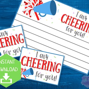 May include: Three white printable cards with the text "I am CHEERING for you!" in red and blue. The cards feature blue megaphones, confetti, and lined spaces for writing. A green hexagon with "INSTANT DOWNLOAD" is also present.