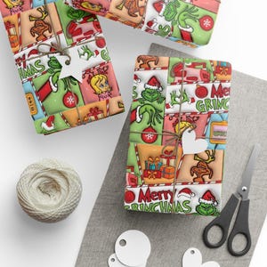 Könnte beinhalten: Weihnachtsgeschenke mit Geschenkpapier im Grinch-Design verpackt. Die Geschenke sind mit Bindfaden verschnürt und mit stern- und herzförmigen Anhängern verziert. Eine Garnrolle, eine Schere und leere Anhänger sind ebenfalls vorhanden.