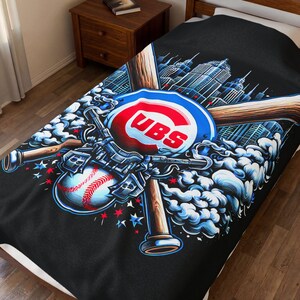 May include: Black blanket featuring a baseball-themed design. The design includes the Chicago Cubs logo, baseball bats, a baseball, and a cityscape. The blanket has a detailed, artistic illustration with blue, red, and white accents.