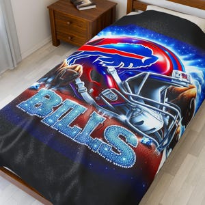 Può includere: Una coperta da letto nera e blu con un casco da football rosso, bianco e blu e la scritta "BILLS" in lettere blu scintillanti. Il design è ambientato su uno sfondo di cielo stellato.