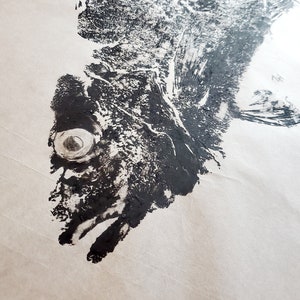 May include: Black and white ink print of a fish on white paper. The fish is facing left and has a large eye.