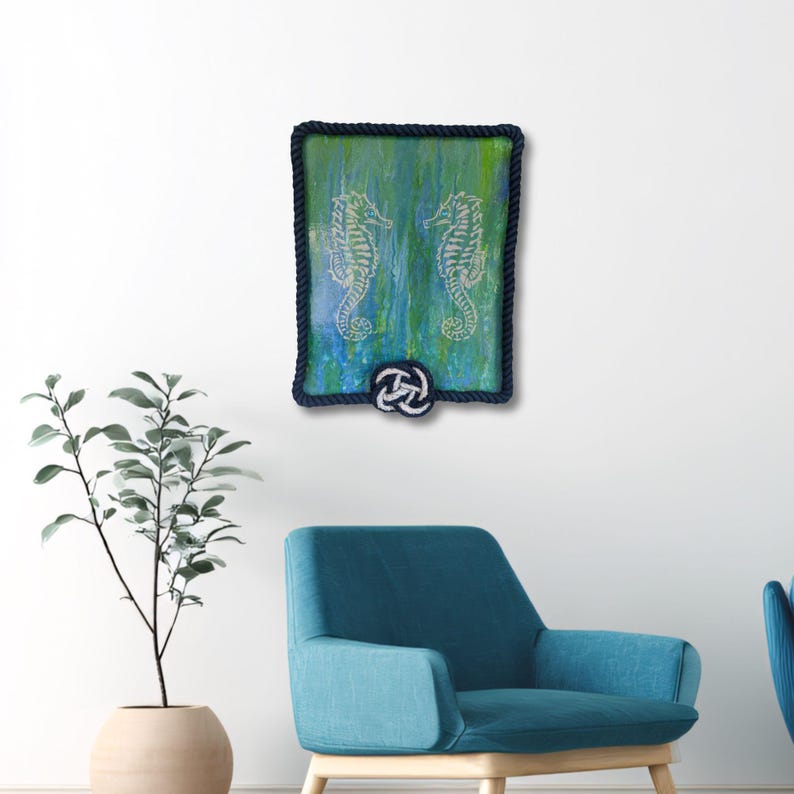 coastal wall decor mockup shows original nautical seahorse painting displayed above chair blue green wall art with rope frame for beach house style