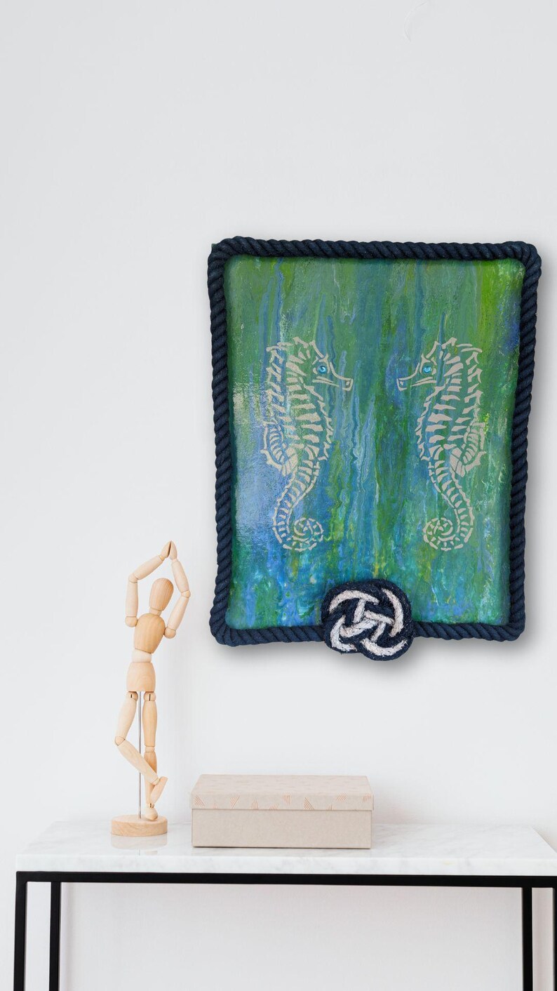 small shelf vignette with original seahorse painting blue green poured background rope frame border nautical wall art for coastal cottage decor