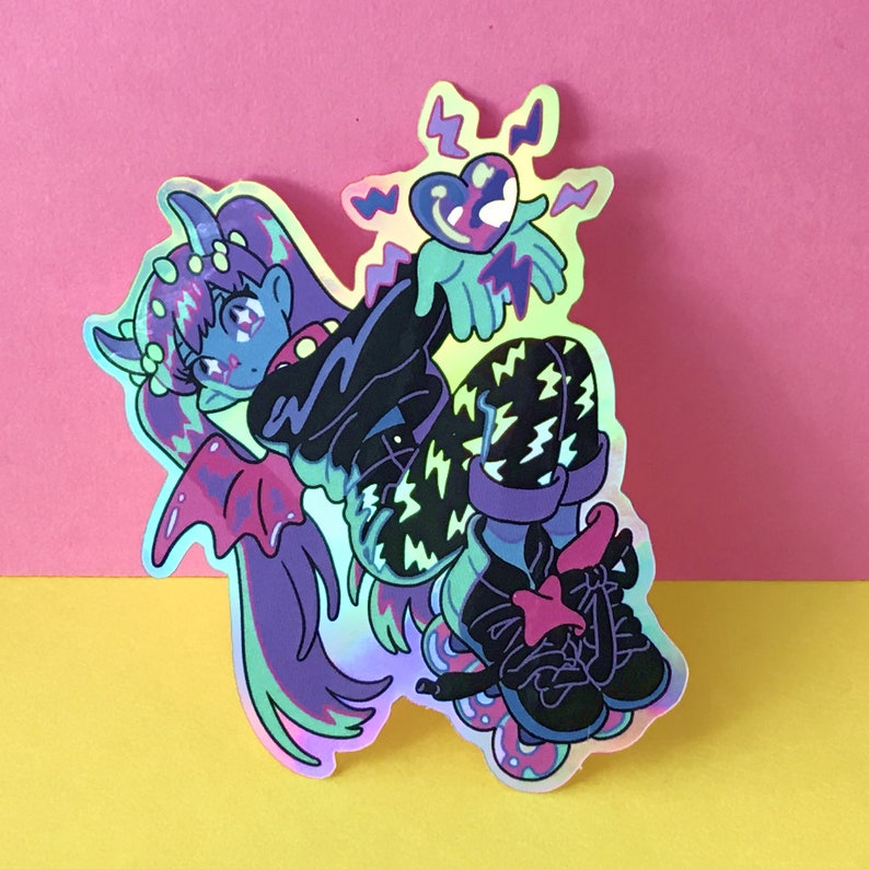 Holographic Rainbow sticker, shiny material, and demon girl jumping and blowing a kiss. Heart in Hand thunder pattern pants, skate blades