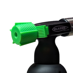 May include: A black and green torch with a green nozzle and the text "Blazer" printed on the side. The torch is made in Japan.