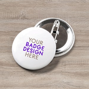 May include: White round button with purple text that says "YOUR BADGE DESIGN HERE" on a wooden surface.