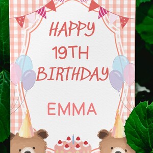 May include: A birthday card with a pink and white gingham background. The card says "HAPPY 19TH BIRTHDAY EMMA" in red lettering. There are illustrations of balloons, party hats, a cake, and two bears. The card is surrounded by green leaves.