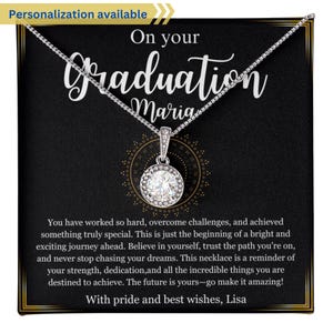 May include: A silver necklace with a clear crystal pendant in a black gift box. The box has a message that reads "On your Graduation Maria" and "You have worked so hard, overcome challenges, and achieved something truly special. This is just the beginning of a bright and exciting journey ahead. Believe in yourself, trust the path you're on, and never stop chasing your dreams. This necklace is a reminder of your strength, dedication, and all the incredible things you are destined to achieve. The future is yours - go make it amazing! With pride and best wishes, Lisa."