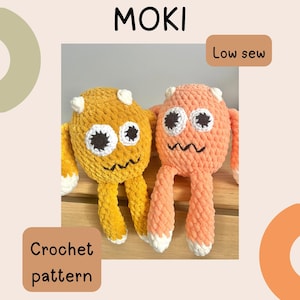 May include: Two plush crochet monster toys, one mustard yellow and one peach, featuring white horns, large white eyes with black pupils, and embroidered black mouths. The image includes the text MOKI, Low sew, and Crochet pattern.