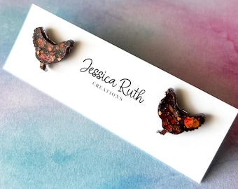 May include: A pair of brown and orange chicken earrings with a glittery finish. The earrings are on a white card with the text "Jessica Ruth Creations".