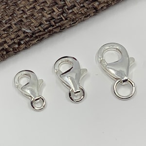 May include: Three silver lobster claw clasps of different sizes. The clasps are commonly used for jewelry making.