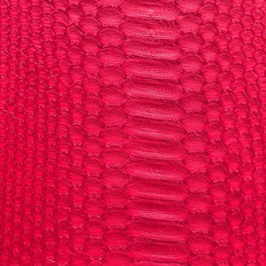 May include: Close-up of a vibrant red snakeskin pattern. The texture features a repeating scale design with a central spine-like ridge. The color is a deep, saturated red, creating a bold and eye-catching visual.