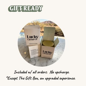 a gift box from Lucky Cactus Co. placed on a marble surface, with a desert landscape visible in the background.