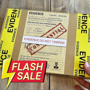May include: A cardboard box marked "EVIDENCE" with yellow tape and text. The box features a "CONFIDENTIAL" stamp and a label stating "EVIDENCE DO NOT TAMPER." A red and yellow "FLASH SALE" sign is in the foreground.