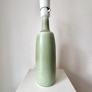 May include: A green ceramic table lamp with a white ceramic lampshade.